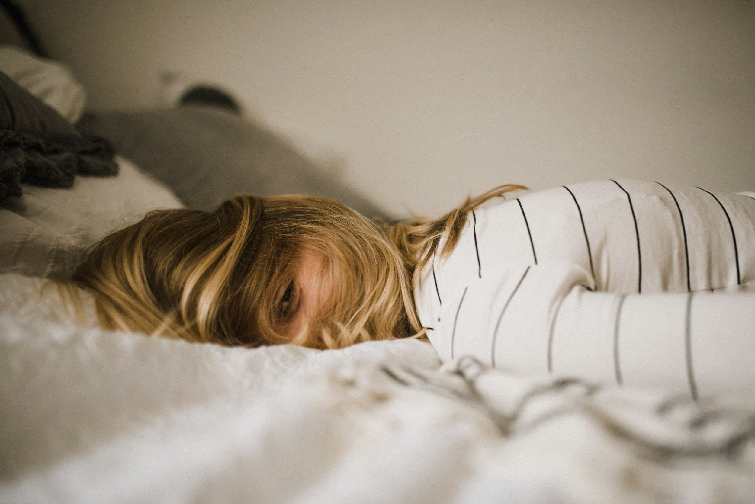 A woman lying face down on a bed.