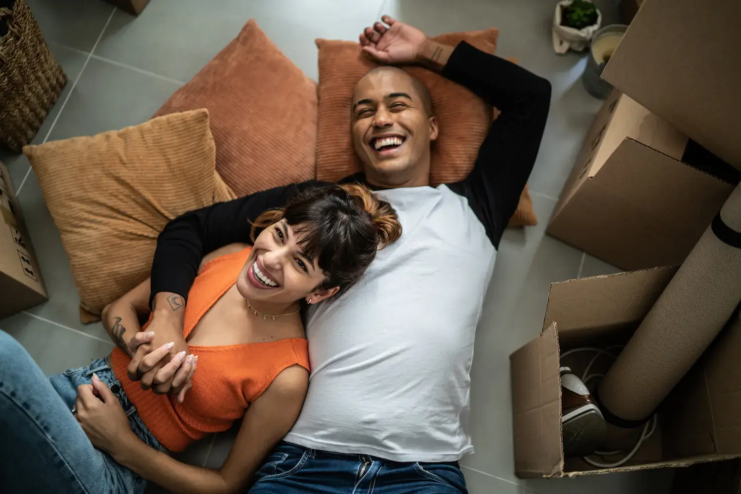 A smiling couple relaxing together on the floor after moving home.